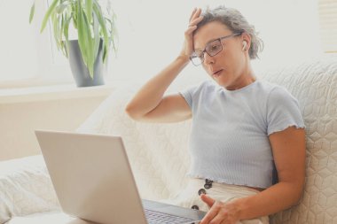 Dizüstü bilgisayar ekranına bakan aşırı stresli genç kız öğrenci, zor görevlerle dolu, sorunu çözmenin bir yolunu düşünüyor. Yüksek endişe, endişe, yüksek tansiyon..