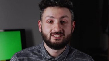 Genç sakallı adam video kaydına konuşuyor.
