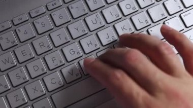 Eller gri klavye üst görünümünde yazılıyor