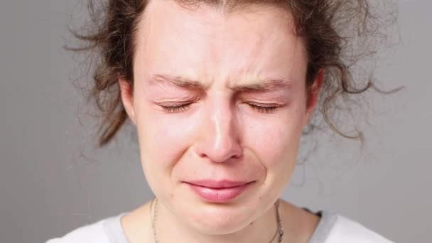 Mladá žena pláče. Detailní záběr na tvář rozčilené dívky, podívá se do kamery a vzlyká. Koncept: trpí ponížením, zlomeným srdcem nebo domácím násilím. psychická oběť šikany — Stock video