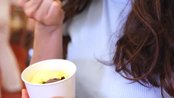 Κοντινό πλάνο. Γυναίκα τρώει νόστιμο παγωτό από ένα φλιτζάνι κουτάλι 4k πλάνα. — Αρχείο Βίντεο