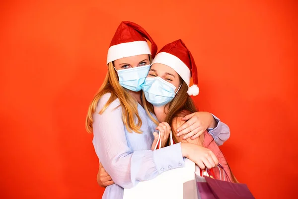 Amigas Con Máscara Quirúrgica Sombrero Navidad Sosteniendo Bolsas Compras Sobre —  Fotos de Stock