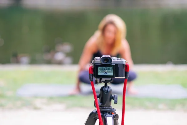 公園でヨガやスポーツの練習をしている間に焦点を当てたデジタルカメラの前に焦点を当てます ブログとブログ テクノロジーの概念を使う人は — ストック写真