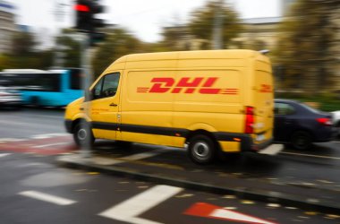 Bükreş, Romanya - Kasım 18, 2020 Bükreş 'te trafikten hızla geçen sarı bir DHL teslimatı. Bu resim sadece editörler içindir..