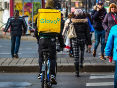Bükreş, Romanya - 28 Ocak 2020: Bir Glovo gıda dağıtım kuryesi Romanya 'nın Bükreş kentinde gıda dağıtıyor.