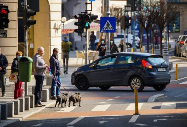 Bükreş, Romanya - 01 Nisan 2021: Romanya 'nın Bükreş kentindeki Zafer Bulvarı bisiklet pistinde insanlar karşıdan karşıya geçmek için bekliyor.