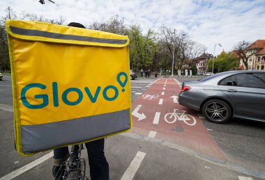Bükreş, Romanya - 15 Nisan 2021: Glovo gıda dağıtım kuryeleri Romanya 'nın Bükreş kentinde gıda dağıtımı yapıyorlar.
