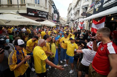 Bükreş, Romanya - 21 Haziran 2021: Ukrayna ve Avusturya partisini destekleyenler, EURO 2020 grup safhasında Ukrayna ile Avusturya arasında oynanan futbol karşılaşması öncesinde eski kentin barlarında ve sokaklarında toplandılar..