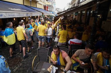 Bükreş, Romanya - 21 Haziran 2021: Ukrayna ve Avusturya partisini destekleyenler, EURO 2020 grup safhasında Ukrayna ile Avusturya arasında oynanan futbol karşılaşması öncesinde eski kentin barlarında ve sokaklarında toplandılar..