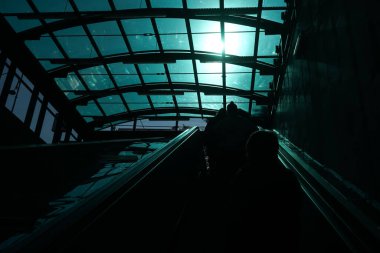 Bükreş, Romanya - 22 Haziran 2021: Cilalı tavandan geçen ışığın yansıması Izvor metro istasyonunun çıkışındaki yürüyen merdivende güçlü bir tezat oluşturuyor.