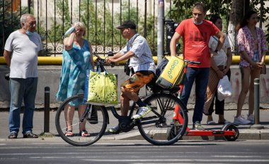 Bükreş, Romanya - 12 Ağustos 2021: Bir Glovo gıda dağıtım kuryesi Romanya 'nın Bükreş kentinde gıda dağıtıyor.