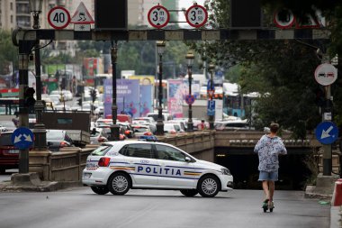 Bükreş, Romanya - 12 Ağustos 2021: Bir polis memuru Bükreş 'teki bir bulvarda meydana gelen trafik kazası nedeniyle yolun kapalı bir bölümünü pas geçmek üzere trafiğe daldı.