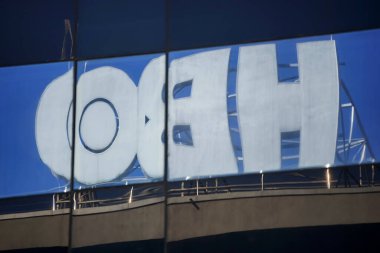 Bükreş, Romanya - 17 Ağustos 2021: Bir binanın tepesinde görülen HBO, American premium kablo ve uydu televizyon ağının yansıması