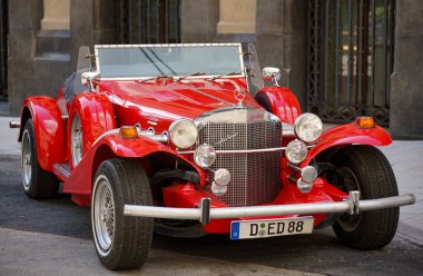 Bükreş, Romanya - 19 Ağustos 2021: 1970 'lerin kırmızı Excalibur SS arabası Marriott' taki Marmorosh Bükreş, Autograph Collection Hotels 'in önüne park edildi.