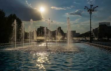 Bükreş, Romanya - 14 Eylül 2021: Bükreş 'te sıcak bir günde Unirii Meydanı Parkı' ndaki fıskiyelerden fışkıran su jetleri