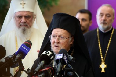 Otopeni, Romanya. 24 Ekim 2025: İstanbul Patriği I. Bartholomew (C) Bükreş Henri Coanda Uluslararası Havalimanı 'na gelişinde Patrik Daniel' in (L) yanında konuşma yaptı.. 