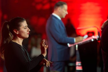 Bucharest, Romania. 19th Nov, 2025: A sign language interpreter (L) translates as Daniel Baluta (R), mayor of Sector 4, reads his speech during the launch of his candidacy for general mayor of Bucharest.