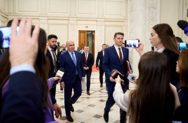 Bükreş, Romanya. 2 Aralık 2025: Romanya Başbakanı Ilie Bolojan (C), Romanya Ulusal Günü münasebetiyle Milletvekilleri Meclisi ve Parlamento Senatosu 'nun Romanya Ulusal Günü' ne adanmış resmi ortak toplantısına gelirken, yargıcılar onu sorgulamaya kalkıştılar..