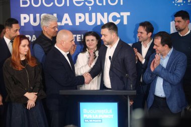 Bükreş, Romanya. 7 Aralık 2025: Ulusal Liberal Parti 'nin (PNL) Bükreş belediye başkanlığına adayı Siprian Ciucu (C-R), sandıkların kapanmasının ardından Ilie Bolojan (C-L) tarafından karşılandı. Anketlere göre Ciucu göründü, 