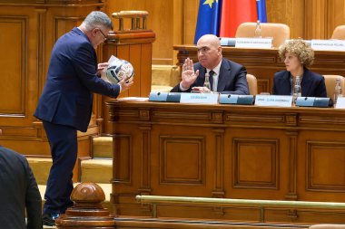 Bükreş, Romanya. 15 Aralık 2025: Romanya Başbakanı Ilie Bolojan (C), P hükümetinin Bolojan hükümetine karşı açtığı gensoru önergesinde kendisine 