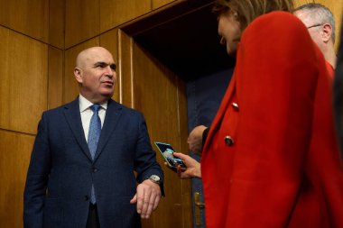 Bükreş, Romanya. 4 Şubat 2026: Romanya Başbakanı Ilie Bolojan, Victoria 'da düzenlenen kısa vadeli hükümet öncelikleri konulu basın toplantısı sonrasında gazetecilerle yaptığı sahte haberlerle ilgili olarak saatinin fotoğraflarını çekmesine izin verdi