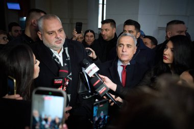 Bucharest, Romania. 11th Feb, 2026: Lawyer Mircea Sinescu (C-L) speaks to the media as far-right ultranationalist Calin Georgescu (C-R) listens at the Bucharest Court of Appeal.