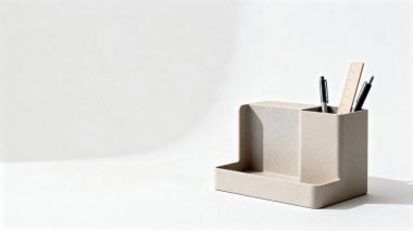 Elinde kalem ve ahşap bir cetvel tutan bej çevre dostu bir organizatör, düzenli ve üretken bir çalışma alanı sürdürmeye yardımcı oluyor..