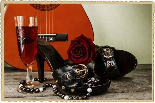 Scarpe con una rosa e una chitarra su un vecchio sfondo di legno — Foto Stock