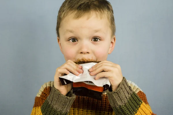 Divertente ragazzo mangiare cioccolato — Foto Stock