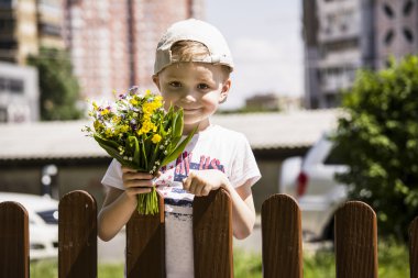 bir buket çiçegi tutan çocuk