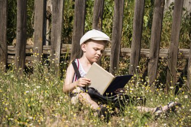 ahşap bir çit yakınındaki bir kitap okurken erkek