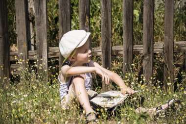 ahşap bir çit yakınındaki bir kitap okurken erkek