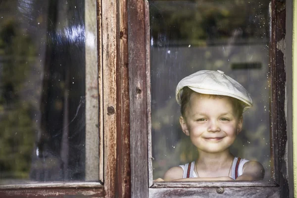 Мальчик смотрит в окно — стоковое фото