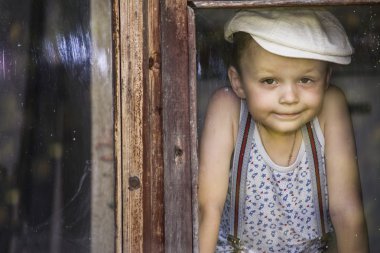 Çocuk bir penceresine bakarak