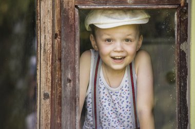 Çocuk bir penceresine bakarak