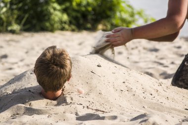 Bir plajda kuma gömülü teen