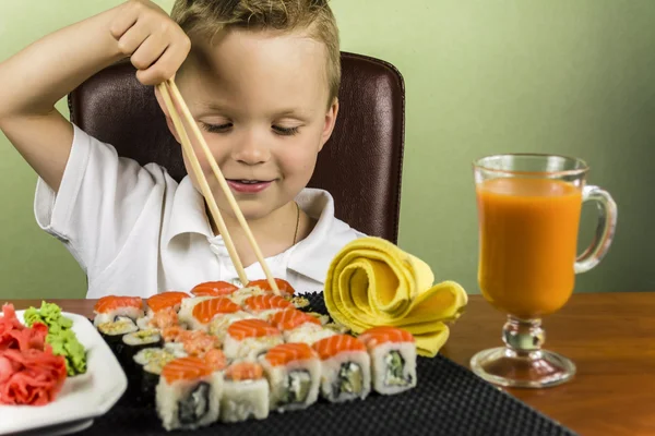 Hauska poika syö sushia — kuvapankkivalokuva