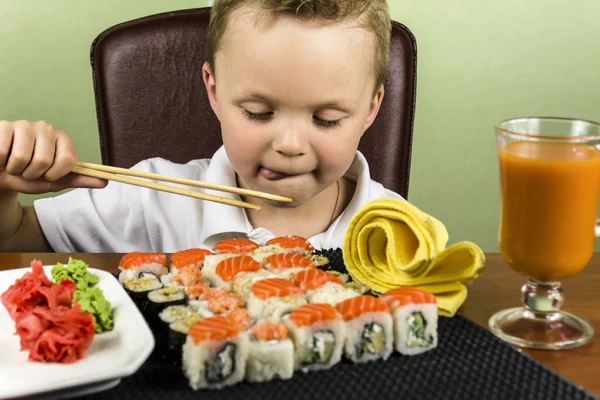 Divertente ragazzo mangiare sushi — Foto Stock