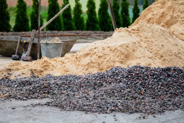 İnşaat ve aletler için yıkılmış taş ve kum, kır evi. 