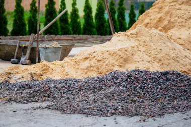İnşaat ve aletler için yıkılmış taş ve kum, kır evi. 