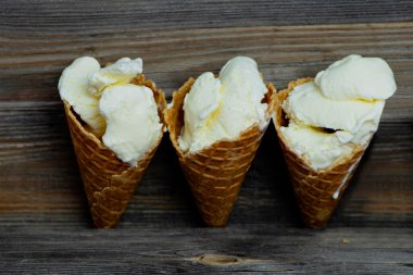 Eski ahşap arka planda waffle bardağında beyaz dondurma. 