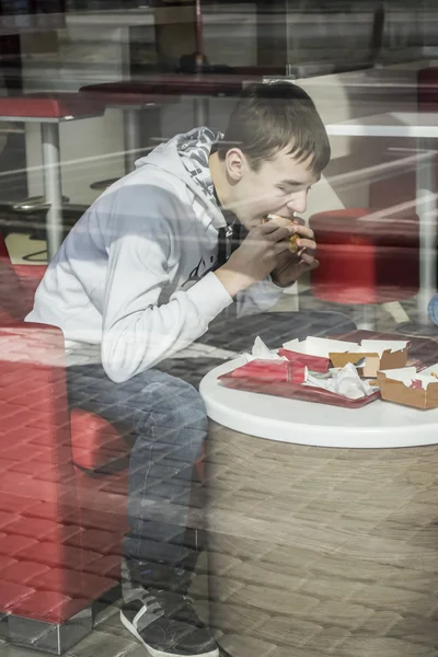 Teenager jíst ve fast food restauraci — Stock fotografie