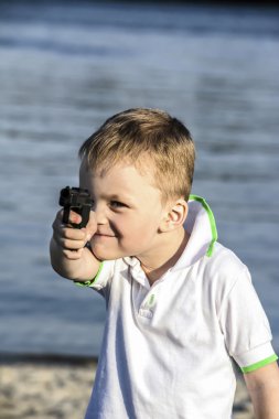 çocuk oyuncak tabanca yaz aylarında kumsalda vuruyor