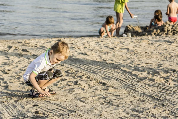 Diğer gezginler arasında sahilde yaz aylarında dinlenme çocuk — Stok fotoğraf