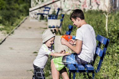 Çocuk ve Genç yaz su tabancası sokakta oynarken