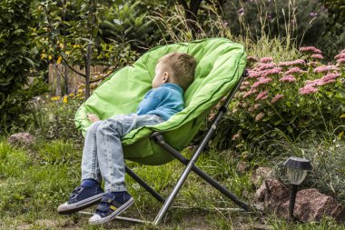 çocuk bahçesinde bir sandalyede uyuyor