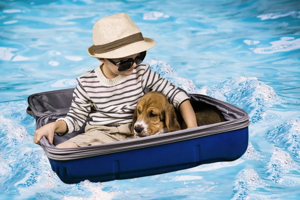 Um menino e um cachorro em uma mala — Fotografia de Stock