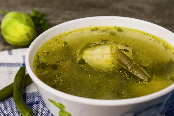 green soup on a wooden table