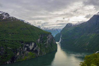Güzel fiyort Geirangerfjord mavi su, gri bulutlar ve beyaz kar ile Norveç 'in yaz mevsiminde Ornesvingen bakış açısını seçer.