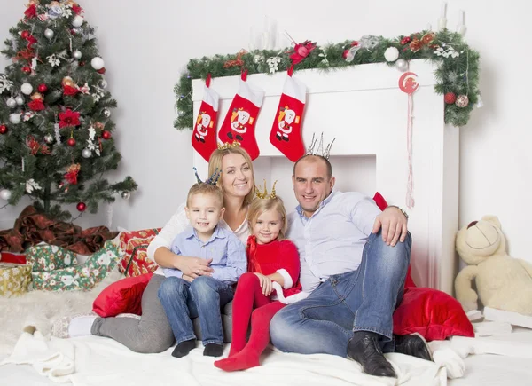 family sitting near the Christmas fireplace